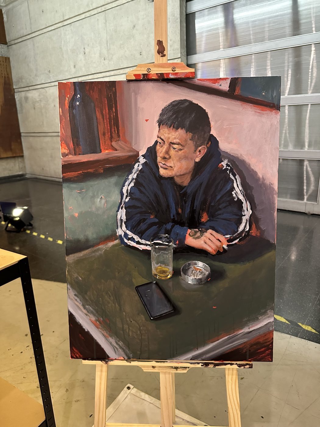Retrato de Juan Vega de un joven apoyado en una mesa de bar