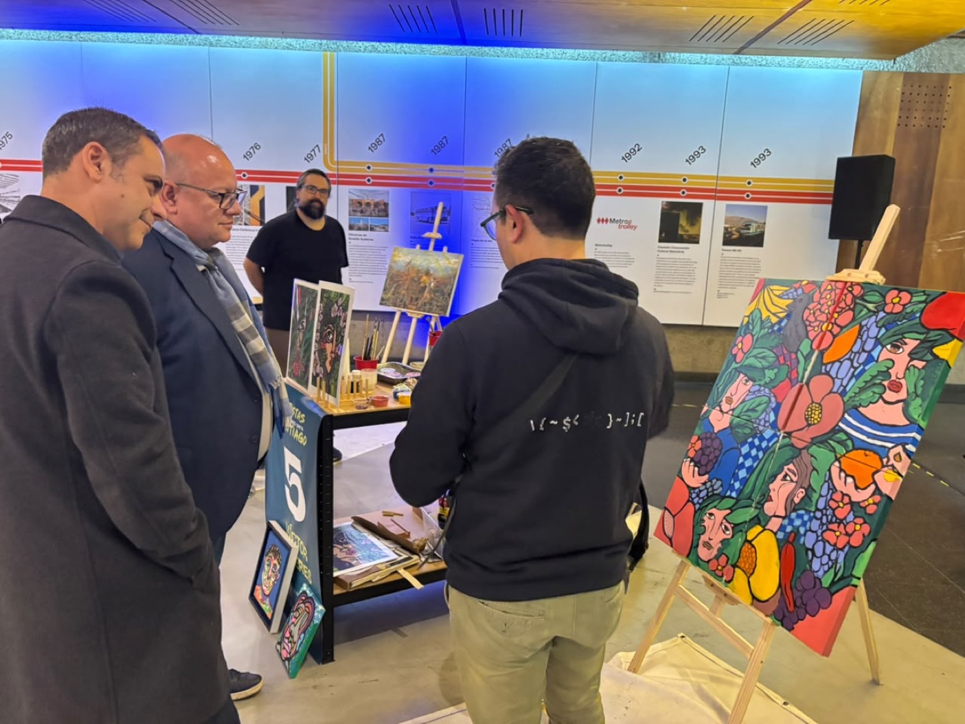 Rodrigo Latorre y Juan Carlos González observan la obra de Víctor Cavieres junto a un joven espectador